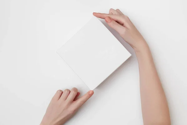 Mock up of white present box in women's hands on the white background — ストック写真