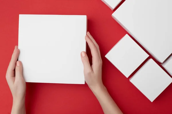 Mock up of white present box in womens hands on the red background — 스톡 사진