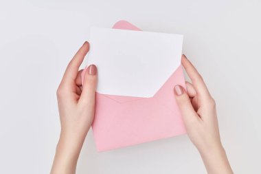 Beyaz arka planda, kadınların kullandığı beyaz kartpostallı pembe bir zarf. Posta kavramı