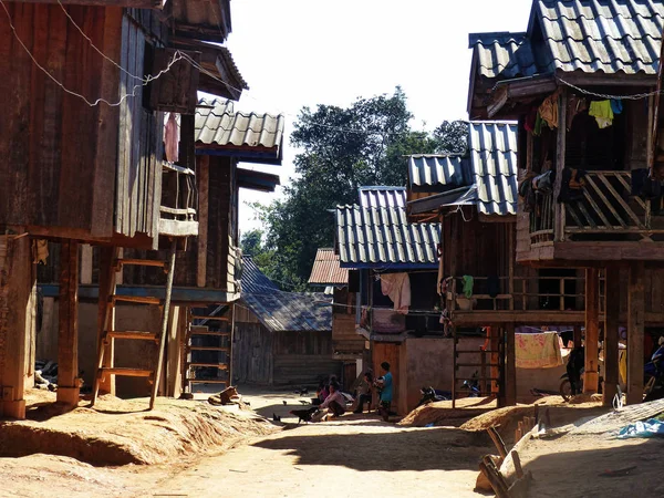 İnsanlar Laos geleneksel bir köyden tozlu sokaklarında dışarı asılı. Ocak 2015.