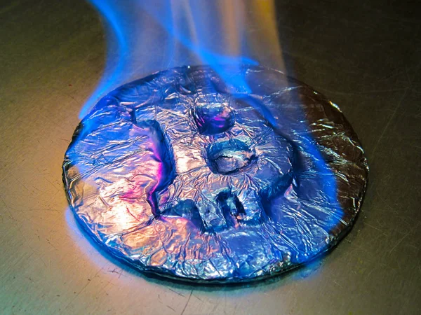 Bitcoin on fire. Real coin is burning with blue flame as symbol of hot price or critical fall — Stock Photo, Image