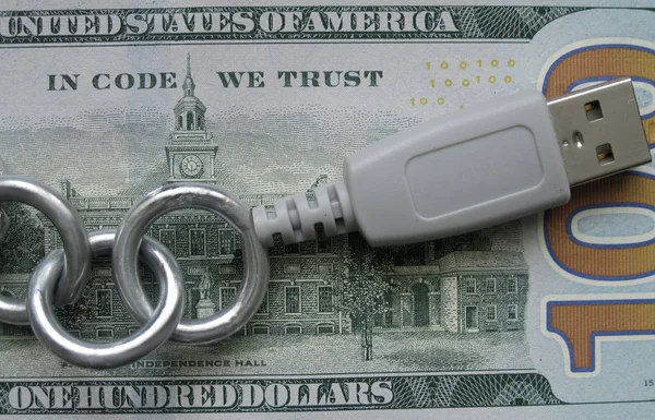 In Code We Trust. Blockchain crypto technology principle. Lettering of block chain banner. Real metal chain joined by USB is on hundred Dollar banknote with changed inscription. It stands for safe, secure, trust