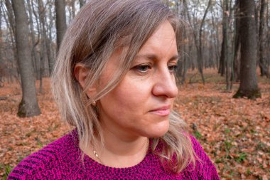 Sonbahar ormanındaki orta yaşlı kadın portresi. Kız seni sevmiyor.