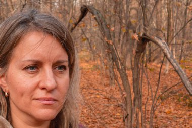 Sonbahar ormanlarında fotokopi çeken 40 yaşındaki bir kadının portresi. Gir