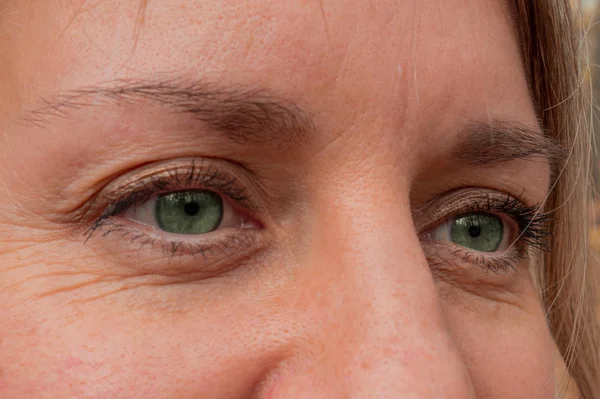 Zbliżenie kobiety w średnim wieku z zielonymi oczami. Prawdziwy dowcip skóry — Zdjęcie stockowe