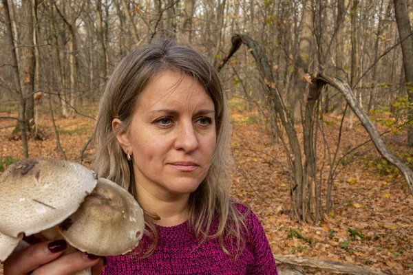 Kadın elinde bir demet büyük mantar tutuyor. Yenilebilir problem 