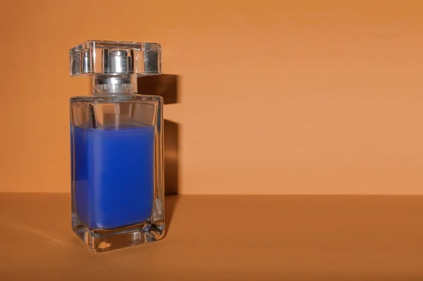 Przezroczysta szklana butelka z niebieskim płynem na brązowym tle wi — Zdjęcie stockowe
