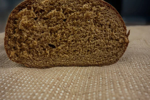 Brown bread on bagging fabric. Closeup view of whole wheat rye b — Stock Photo, Image