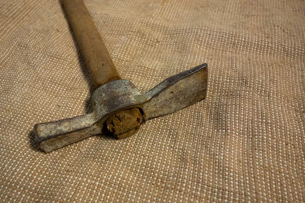Miner hammer like pickaxe or mattock on bagging fabric backgroun — Stock Photo, Image