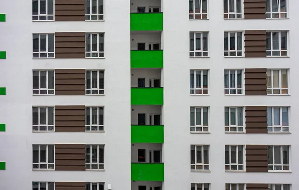 Building facade with windows and green balconies. Flat view pattern. Modern urban architecture background. Mortgage to buy private apartment concept