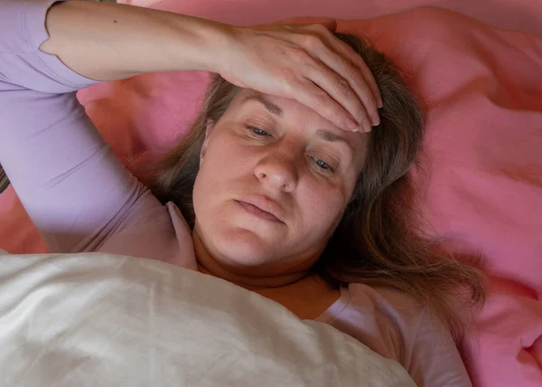 Orta yaşlı bir kadının yüksek ateşi var. 40 yıl boyunca kadınlar yatakta yatar ve elleriyle alnına dokunurlar. O hasta ve hasta. Sağlık sorunları olan kız portresi