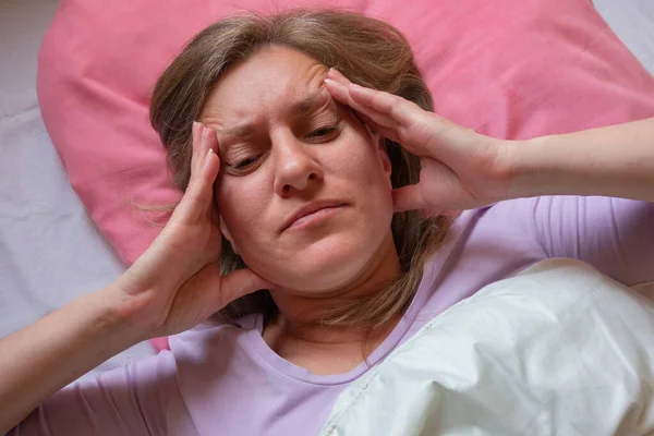中年妇女头疼 40岁的女人躺在床上 用手碰着头 她身体不舒服 有健康问题的女孩特写 — 图库照片