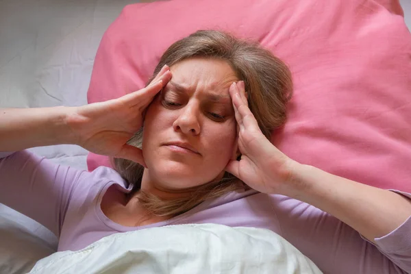 中年妇女头疼 40岁的女人躺在床上 用手碰着头 她身体不舒服 有健康问题的女孩特写 — 图库照片