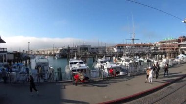 San Francisco, ABD - Haziran, 03, 2019 - San Francisco 'daki rıhtım manzarası marinadaki tekneleri ve kaldırımdan geçen insanları gösteriyor.