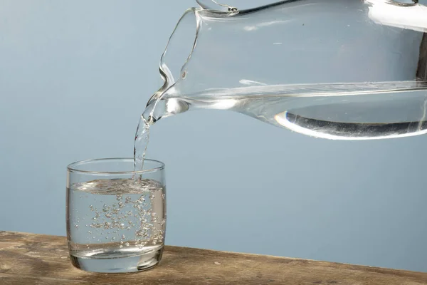 Persona che riempie una tazza d'acqua con un barattolo . — Foto Stock