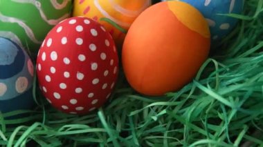 Saman yeşili arka planda Paskalyayı simgeleyen boyanmış yumurtalar.