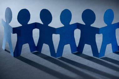 Sendika ve takımı simgeleyen el ele tutuşan kağıt bebekler..