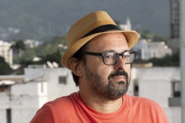 Gözlüklü adam panama şapkası takıyor.