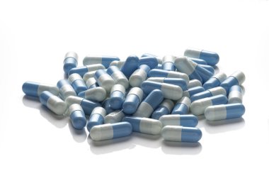 Beyaz arkaplanda beyaz ve açık mavi kapsüller