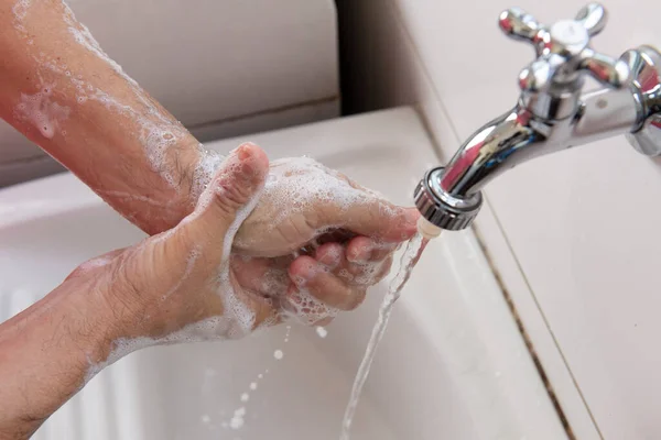 person washing hands to sanitize covid-19 bacteria