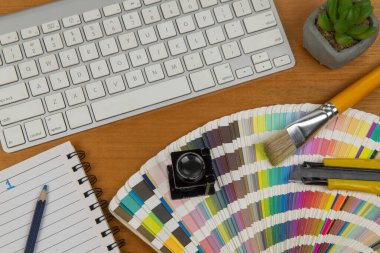 stil ve büyüteç içeren renk ölçeği ve yaratıcı ofis ortamında bir element oluşturmak için bir not defteri ve klavye.