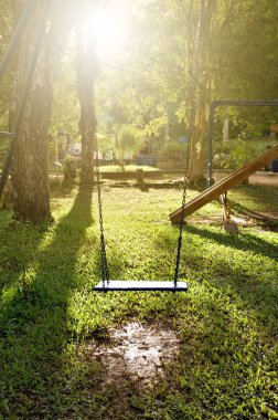 Güneşli bir gün, güzel gün batımı, oyun alanında salıncak.