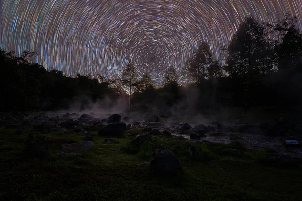 夜の岩の上に回転する星と熱い水蒸気. — ストック写真