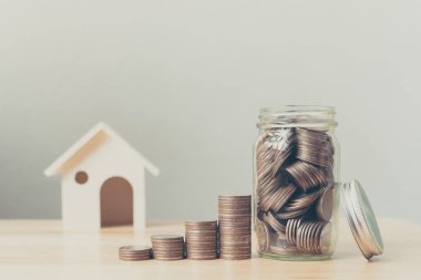 Mülk yatırımı ve ev kredisi finansal konsepti, tahtadan evi olan para yığını
