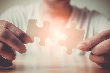 Strategic management and business solutions for success, Hand of male connecting jigsaw puzzle