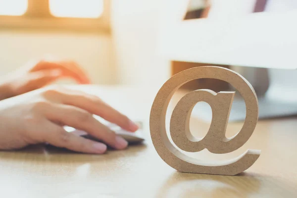 Conceito de email marketing, Mão usando mensagem de envio de computador com símbolo de endereço de e-mail de madeira — Fotografia de Stock