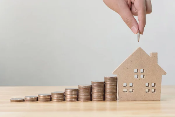 Investimento immobiliare e mutuo ipotecario concetto finanziario, mano mettendo soldi moneta stack con casa in legno — Foto Stock