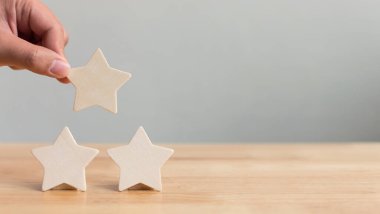 Masaya beş yıldızlı ahşap bir el koyuyorum. En iyi iş hizmetleri derecelendirme müşteri deneyimi konsepti