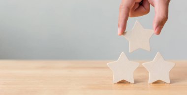 Masaya beş yıldızlı ahşap bir el koyuyorum. En iyi iş hizmetleri derecelendirme müşteri deneyimi konsepti