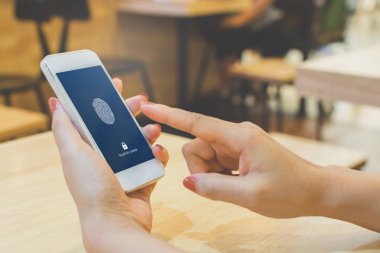 Akıllı telefon tutan kadınları eline al ve cep telefonunun kilidini açmak için parmak izi biyometrik kimliğini tara