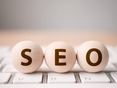 Arama motoru optimizasyonu konsepti. Klavyede SEO sözcüğüyle ahşap blok küresi şekli ve metin için boş kopyalama alanı
