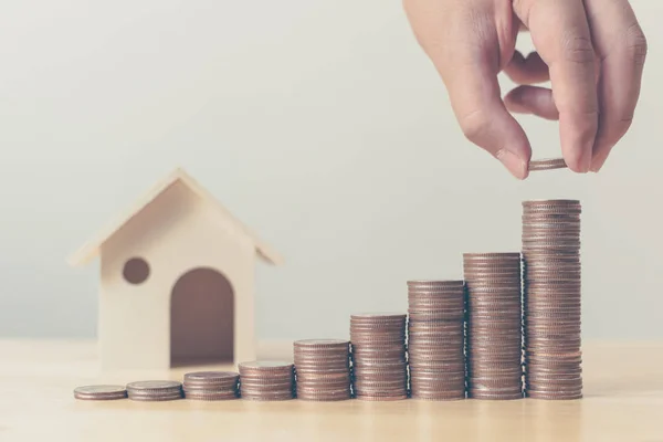 Investimento immobiliare e mutuo ipotecario concetto finanziario, mano mettendo soldi moneta stack con casa in legno — Foto Stock