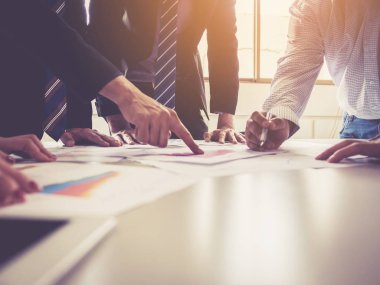 Bir grup işadamı, şirketin performansını ve büyüme kurumunu bilgi veri kağıdıyla analiz ediyor.