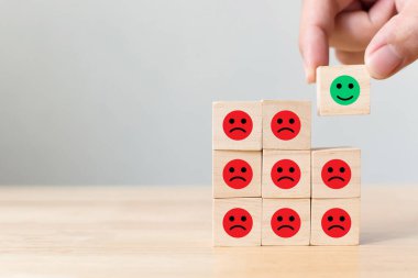 Elle seçilen tahta blok ikon yüzlü, duygu dolu mutluluk ve üzüntü, Eşsiz, farklı düşün, bireysel ve kalabalık konseptinden uzak dur.