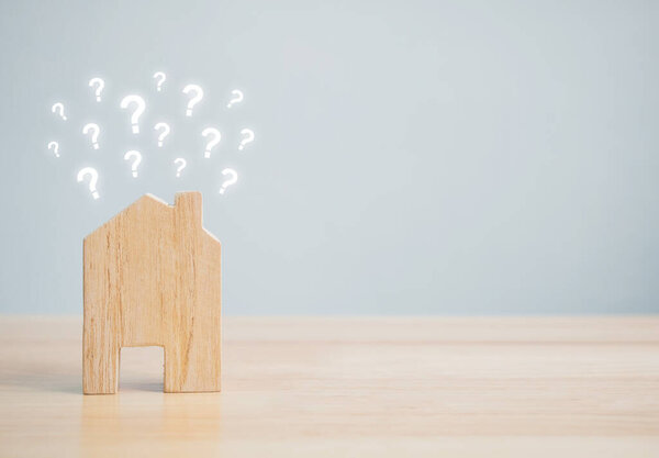 Увлажните домашнюю форму вопросительным знаком на деревянном столе и копирайтом для вашего текста. Идеи концепции дома