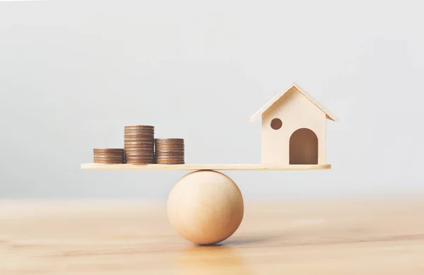 Ahşap ev ve para paraları ahşap ölçekte istiflenir. Emlak yatırımı ve konut kredisi finansal emlak kavramı