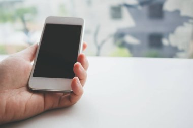 Beyaz cep telefonlu, beyaz ekranlı, siyah akıllı telefonlu bir kadının görüntüsü.