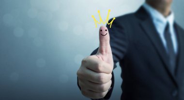 Businessman showing hand sign thumb up with crown and smiley face icon, The excellence of the business or customer experience service concept clipart