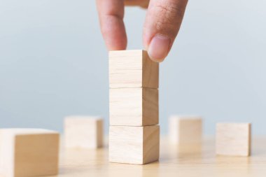 Tahta masa ile ahşap bloğu üst üste dizme el düzenlemesi. Büyüme süreci için iş konsepti