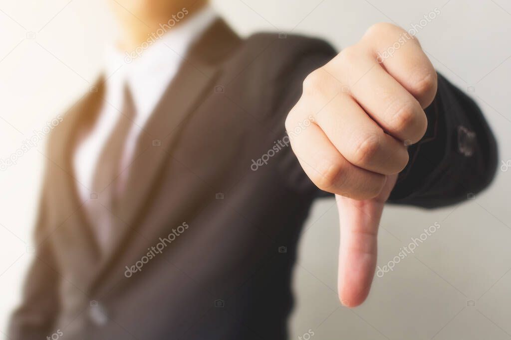 Businessman hand showing thumb down sign gesture. Dislike or bad concept