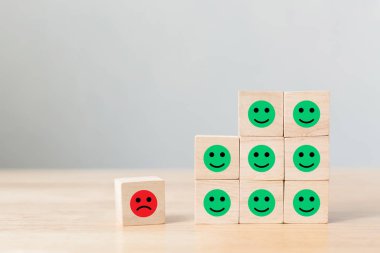 Tahta blok ikonla yüzleşir duygusal mutluluk ve üzüntü, Eşsiz, farklı düşün, bireysel ve kalabalığın konseptinden uzak dur