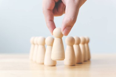 İnsan kaynakları, yetenek yönetimi, işe alım çalışanı başarılı iş dünyası lideri konsepti. El, kalabalığın arasından çıkan tahta insanları seçer..