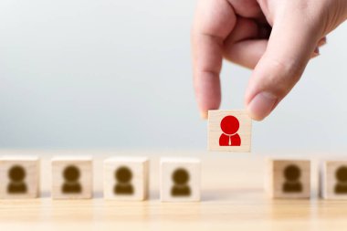 Bir iş adamının eli, kalabalığın arasında duran ikon insanların bulunduğu tahta bir küp bloğu seçer. Başarılı iş dünyası takım lideri konsepti