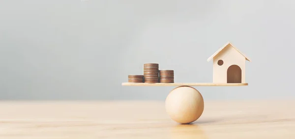 Ahşap ev ve para paraları ahşap ölçekte istiflenir. Emlak yatırımı ve konut kredisi finansal emlak kavramı