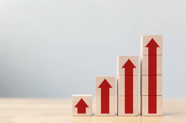 İş büyümesi için merdiven kariyer yolu kavramı. Tahta bloklar basamakları ok eşliğinde istifliyor.