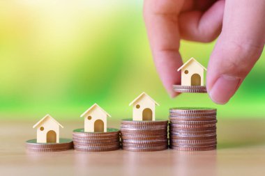 Emlak yatırımı ve ev kredisi finansal konsepti. El koymak para yığını Büyüyen büyüyen ev adım